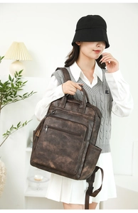 Detail of dark brown faux leather backpack with side pockets and tassel accent