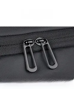 Close-up of durable dual metal zippers on black textured fabric for large travel backpack