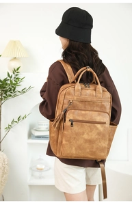 Detail view of brown PU leather backpack with vintage texture and stylish tassel charm