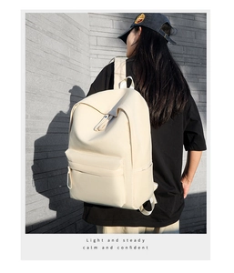 Close-up of minimalist cream Oxford cloth backpack with premium texture and side pockets