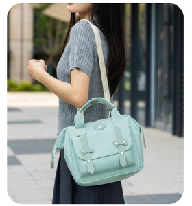 Detail of mint green waterproof mummy bag with metal buckle straps and brand logo