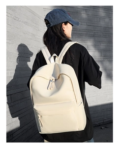 Close-up of minimalist cream white oxford backpack with wide straps and zipper detail