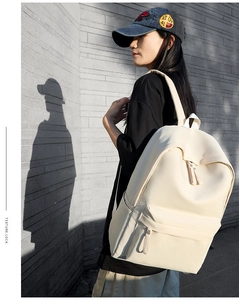 Minimalist cream canvas backpack shown in an outdoor setting with aesthetic sunlight and shadows