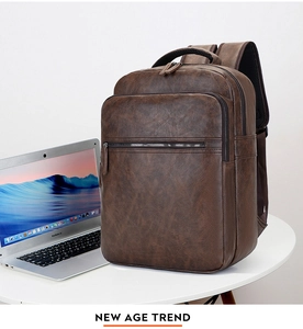 Dark brown leather business backpack with a laptop on a white desk for work