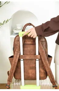 Brown PU leather backpack detail showing the luggage strap for easy travel attachment