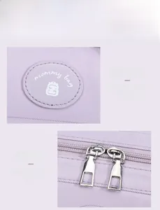 Detail of the lavender mommy bag with dual metal zippers and circular logo patch