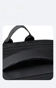 Detail of the thickened padded handle with breathable mesh on the black travel backpack