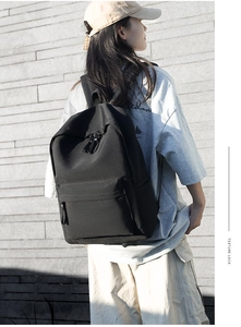 Outdoor shot of the minimalist black Oxford fabric backpack showing durable texture