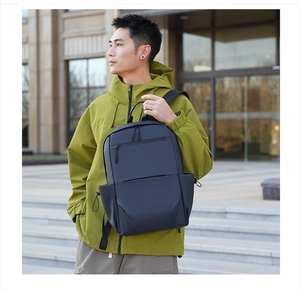 Waterproof dark blue commuter backpack with side drawstring pockets on a male model
