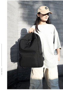 Detailed view of back straps on a minimalist black Oxford cloth backpack for daily travel