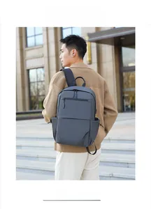 Waterproof dark grey business backpack worn by model in a street setting closeup