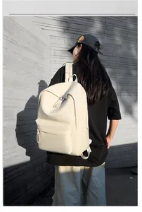 Outdoor view of off-white minimalist travel backpack featuring wide straps and side pocket