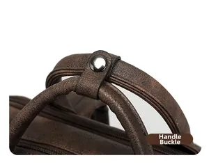Detail of vintage brown leather backpack showing reinforced handle with silver metal clasp