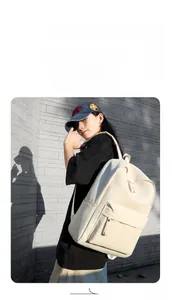 Beige oxford fabric backpack detail showing front zipper pocket and side water bottle pouch