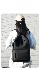 Close-up of black minimalist oxford backpack with water bottle pocket shown on model