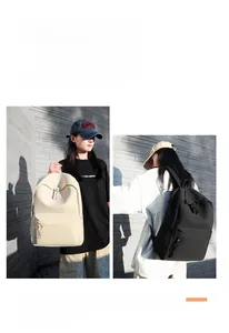 Detail view of adjustable straps and side pockets on cream and black oxford backpacks
