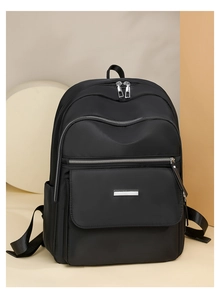 Vue détaillée d'un sac à dos noir en tissu Oxford avec poches zippées et détails métalliques