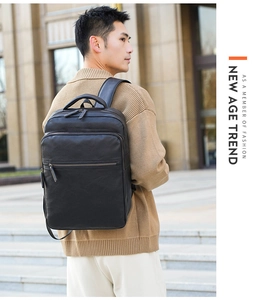 Outdoor model shot of black faux leather backpack with side handle and zipper detail