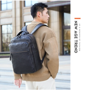 Outdoor shot of a man wearing a black PU leather backpack with sleek zippers and adjustable straps