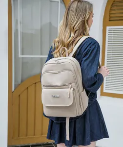 Outdoor view of woman wearing a stylish beige waterproof nylon backpack with pockets