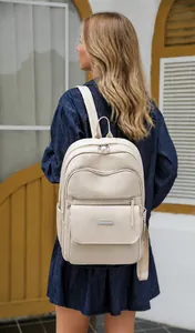 Close-up of beige Oxford fabric backpack featuring multiple zip layers and side pockets