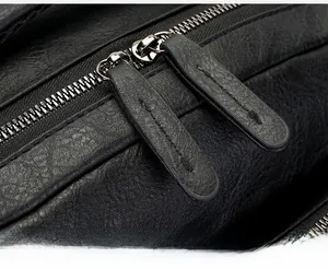 Close-up of durable silver metal zippers with premium black leather pullers on backpack
