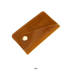 Detail view of handmade vintage cowhide card holder with silver snap and fine stitching