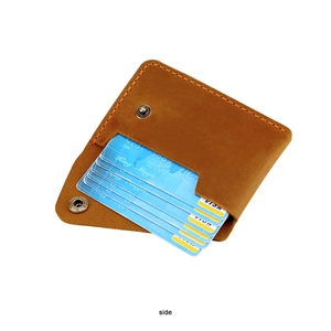 Detail view of brown vintage leather wallet showing yellow stitching and card slots