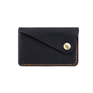 Detailed view of handmade black leather card holder with contrast orange stitching and gold snap