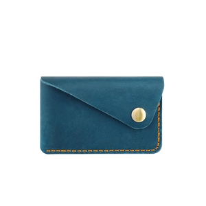 Close-up of handmade blue leather card holder with contrast orange stitching and gold button