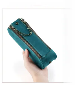 Detail of crazy horse leather pencil case with double zippers and gold chain handle