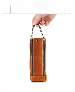 Detail of vintage crazy horse leather pencil case with dual zippers and metal chain handle