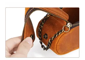 Close-up of durable bronze metal snap button on retro brown crazy horse leather pouch