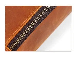 Macro shot of durable double stitching and metal zipper on brown crazy horse leather pouch
