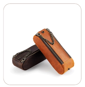 Detail of vintage leather pencil pouches in dark and light brown with metal chain handles