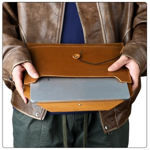 Detail of crazy horse leather laptop sleeve with retro leather strap closure for iPad