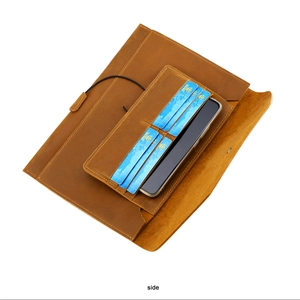 Macro view of brown vintage leather laptop sleeve interior with card slots and phone pocket