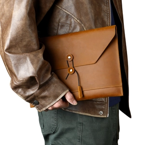 Close-up of vintage brown leather document folder with unique string and disk closure system