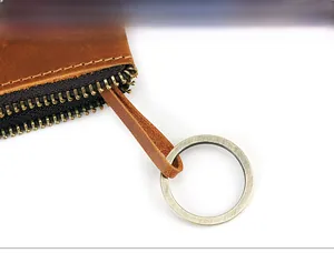 Close-up of vintage leather bag zipper with bronze metal key ring and sturdy puller