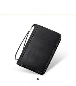 Detail of black leather business clutch bag with orange contrast stitching and wrist strap