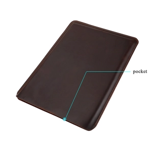Detail of dark brown leather laptop sleeve with yellow stitching and side pocket
