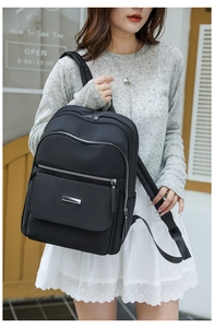 Détail du sac à dos en nylon imperméable avec fermetures argentées et poches