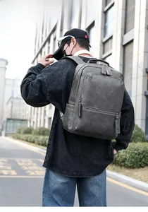 Detail of dark grey textured PU leather backpack with waterproof surface and zipper pull