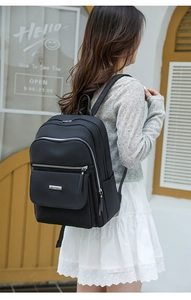 Détail d'un sac à dos en nylon noir avec compartiments multicouches et poche à rabat aimanté