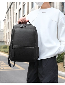 Close-up of a black PU leather business backpack with durable zippers and side pockets