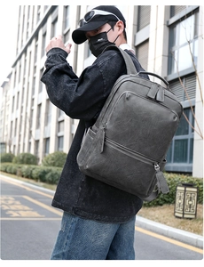 Side view of man carrying the dark gray faux leather backpack for business and daily commute