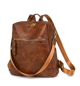 Detail view of brown PU leather backpack texture with golden zippers and side pockets