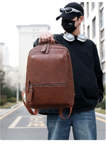 Close-up of brown PU leather backpack featuring vintage lychee texture and front zipper