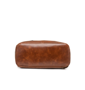 Detail view of the wide-base caramel brown leather backpack with reinforced stitching