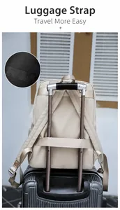 Close-up of the beige oxford backpack showing the luggage strap for suitcase handles